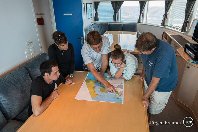 Living Oceans Foundation Chief Scientist Dr. Andrew Bruckner discusses the Great Barrier Reef Zoning Map with some members of his team, showing which areas were selected for their coral and fish survey.